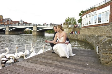 Bride and groom feeding ducks on Sir Christopher Wren's private dock